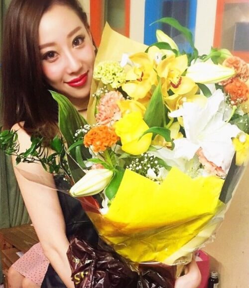 秋倉諒子さんが大きな花束を持っている写真画像