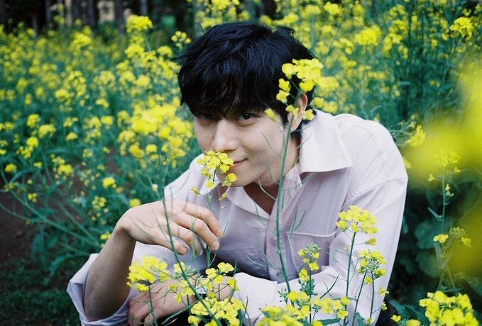 黄色の花を持って微笑むキム・ヨンデの画像